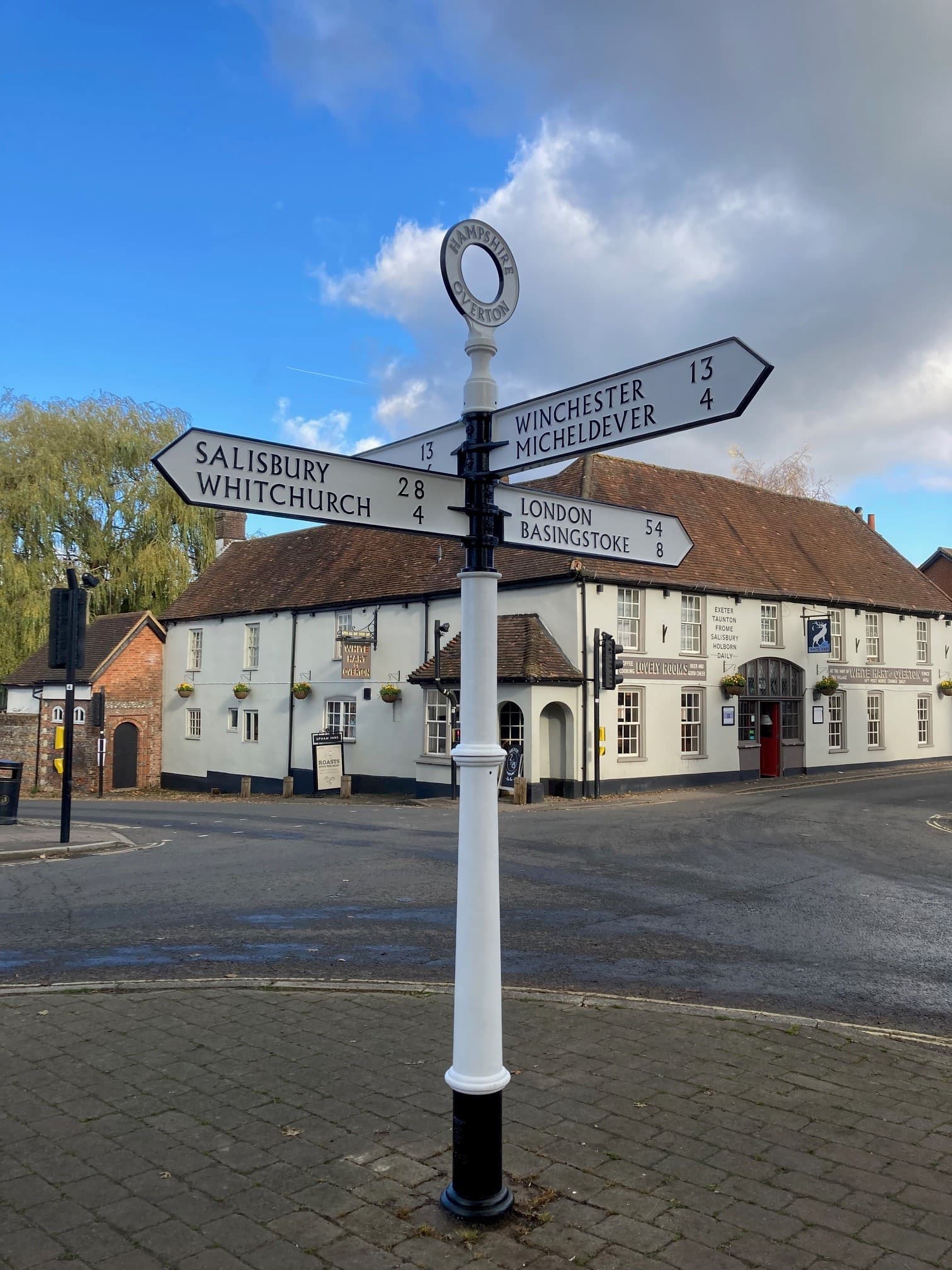A road sign post pictured in the village of Overton featuring place names Winchester, Micheldever, Salisbury and Whitchurch.